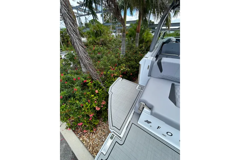 Slide: The Image of 2026 Four Winns H9 OB boat deck near tropical plants and palm trees. - 17