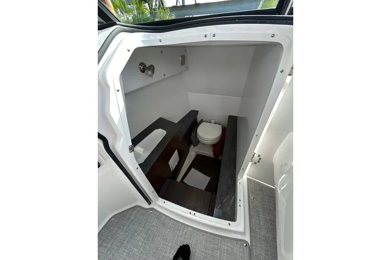 Slide: The Image of 2026 Four Winns H9 OB boat interior with compact bathroom and toilet. - 8