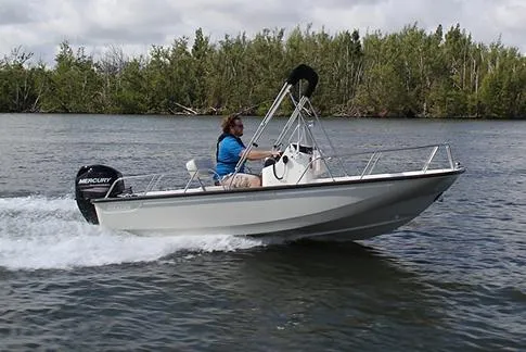 Slide: The Image of 2026 Boston Whaler 150 Montauk boat with outboard motor, parked on a trailer. - 1