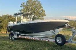 The Image of 2023 Glasstream 328 SCX boat on trailer, parked on grass with tree background. - 0