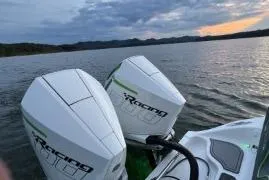 Slide: The Image of 2023 Glasstream 328 SCX boat with dual racing engines on a serene lake at sunset. - 10