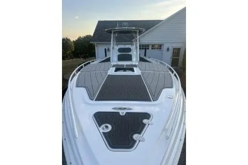Slide: The Image of 2023 Glasstream 328 SCX boat with sleek deck design, parked near a house. - 2