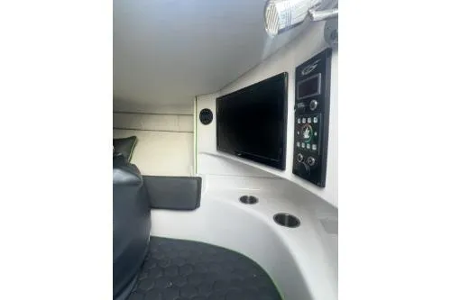 Slide: The Image of 2023 Glasstream 328 SCX cabin interior with seating, control panel, and TV screen. - 23