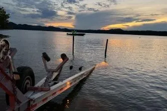 Slide: The Image of Sunset over lake with Glasstream 328 SCX boat trailer, 2023 model, in foreground. - 32