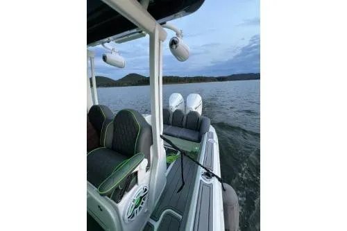 Slide: The Image of 2023 Glasstream 328 SCX boat on a lake, featuring sleek seating and dual engines. - 7