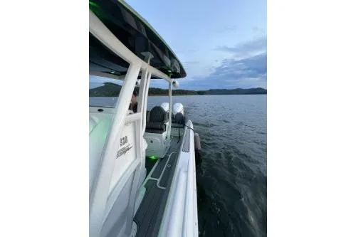 Slide: The Image of 2023 Glasstream 328 SCX boat on calm water at sunset. - 8