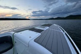 Slide: The Image of 2023 Glasstream 328 SCX boat on a serene lake at sunset. - 9