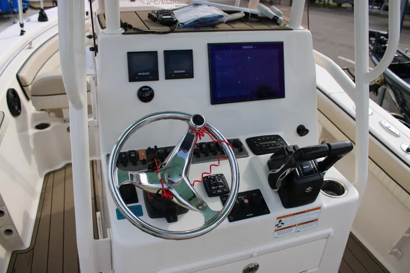Slide: The Image of 2022 Sea Chaser 24 HFC boat dashboard with steering wheel and navigation controls. - 10