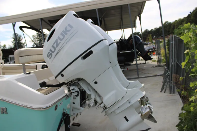 Slide: The Image of 2022 Sea Chaser 24 HFC with Suzuki outboard motor in a covered dock. - 17