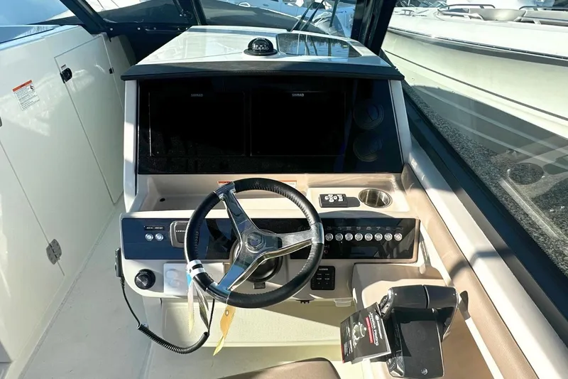 Slide: The Image of 2026 Boston Whaler 330 Vantage helm with steering wheel and control panel. - 18