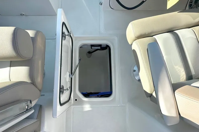 Slide: The Image of 2026 Boston Whaler 330 Vantage interior storage compartment with open hatch and seating. - 19