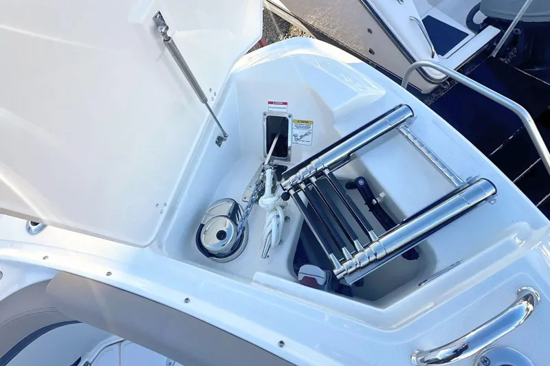 Slide: The Image of 2026 Boston Whaler 330 Vantage boat storage compartment with ladder and equipment. - 34