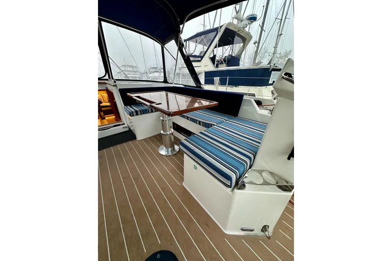 Slide: The Image of 2020 Bavaria C50 yacht interior with striped seating and wooden table. - 43