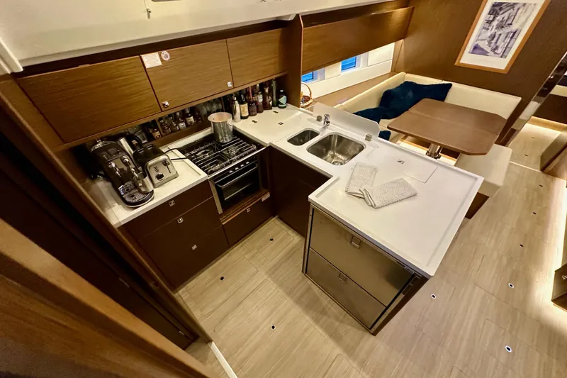 Slide: The Image of Modern kitchen interior on a 2020 Bavaria C50 yacht, featuring appliances and dining area. - 46