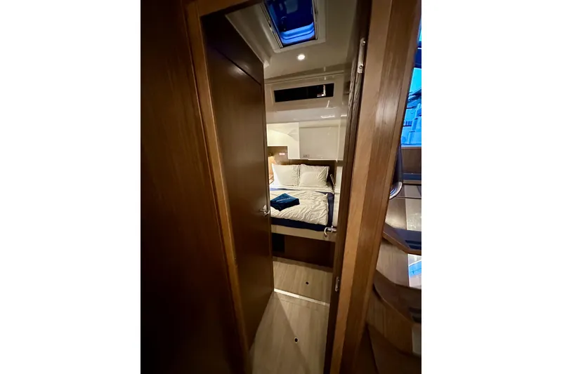 Slide: The Image of Interior of 2020 Bavaria C50 yacht, featuring a cozy bedroom with wooden accents. - 58