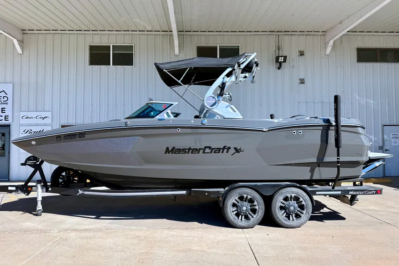 Slide: The Image of 2020 MasterCraft XStar boat on trailer, parked outside a building. - 1