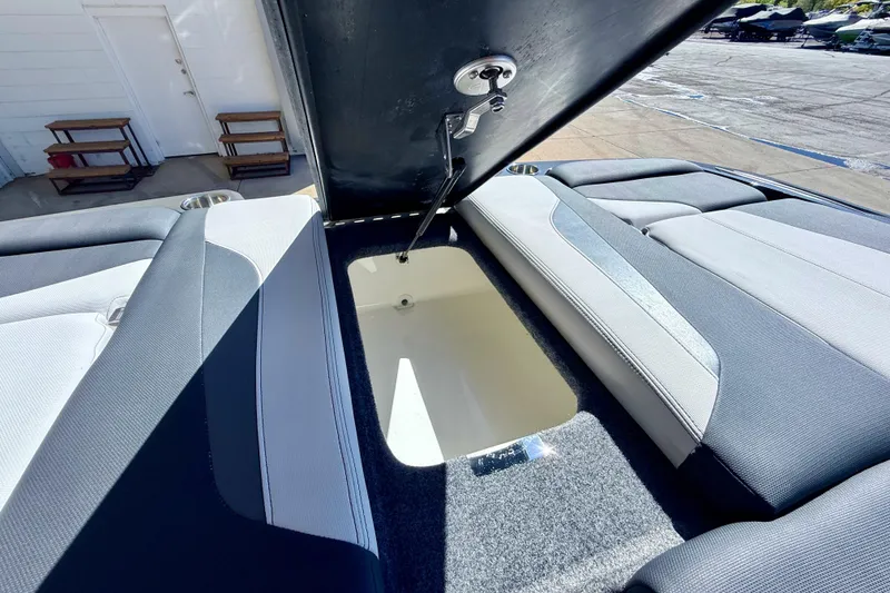 Slide: The Image of 2020 MasterCraft XStar boat storage compartment with open lid, showcasing interior space. - 34