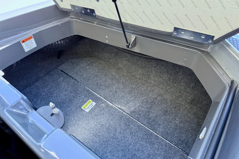 Slide: The Image of 2020 MasterCraft XStar storage compartment with carpeted interior and open lid. - 36