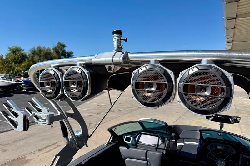 Slide: The Image of 2020 MasterCraft XStar boat with mounted speakers and wakeboard racks under clear blue sky. - 40