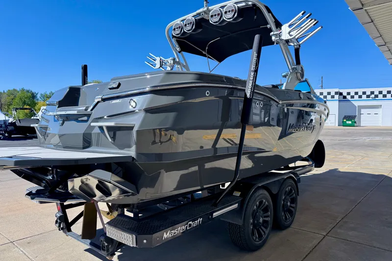 Slide: The Image of 2020 MasterCraft XStar boat on trailer, sleek design, parked outdoors under clear blue sky. - 8