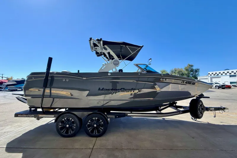Slide: The Image of 2020 MasterCraft XStar boat on trailer under clear blue sky. - 9