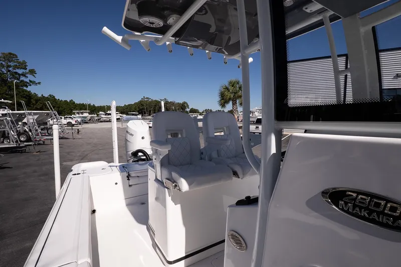 Slide: The Image of 2026 Blazer Bay Makaira 2800 boat interior with seating and console, parked outdoors. - 18