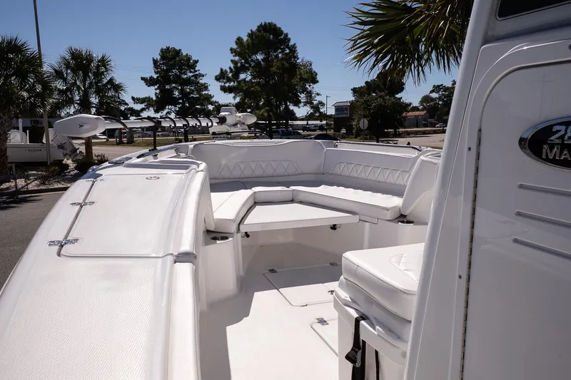 Slide: The Image of 2026 Blazer Bay Makaira 2800 boat interior with white seating and palm trees in background. - 23