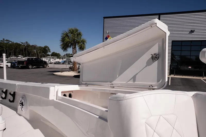 Slide: The Image of 2026 Blazer Bay Makaira 2800 boat with open storage compartment, white seating, and palm tree background. - 25