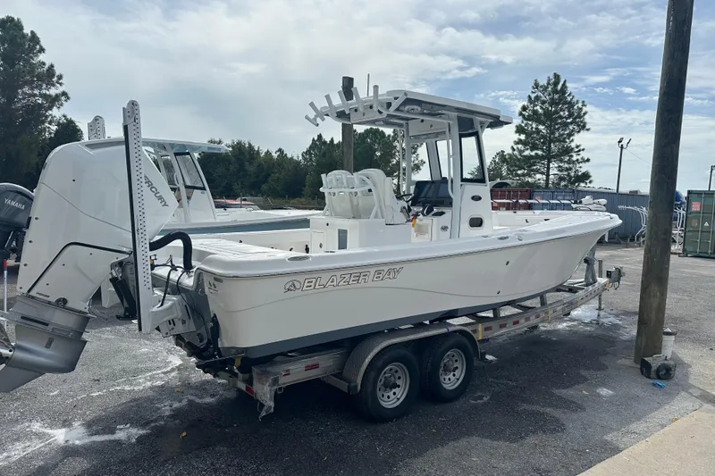 Slide: The Image of 2026 Blazer Bay Makaira 2800 boat on trailer, parked outdoors near palm trees. - 4