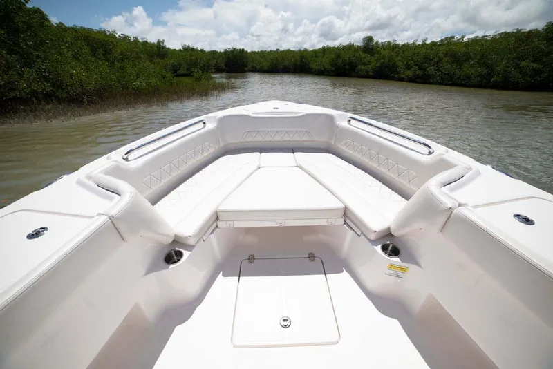 Slide: The Image of 2026 Blazer Bay Makaira 2800 boat interior with seating and storage, parked in a marina. - 8