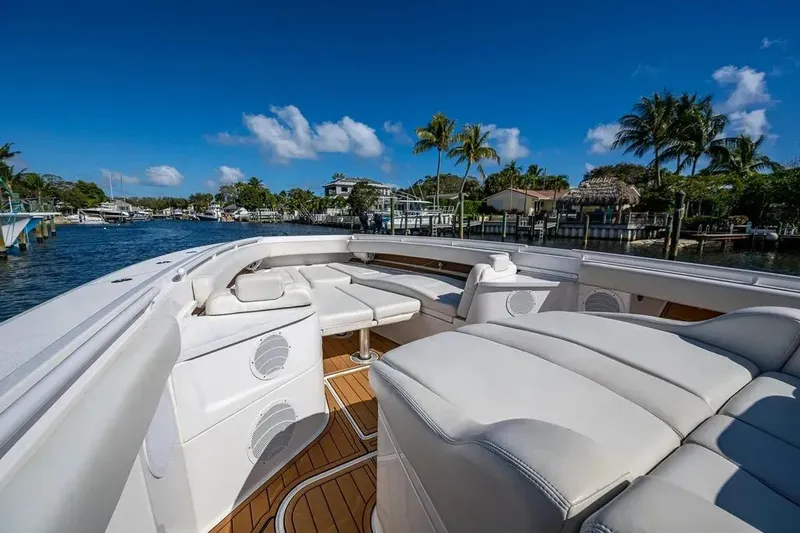 Slide: The Image of Luxury 2020 HCB 53 Sueños boat with spacious seating, docked near palm trees and waterfront homes. - 17