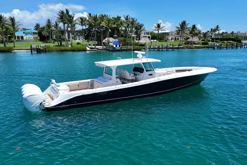 Slide: The Image of 2020 HCB 53 Sueños boat on clear blue water near a tropical shoreline. - 2