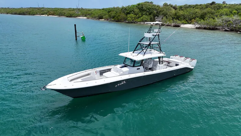Slide: The Image of 2019 HCB 53 Sueños boat on turquoise water near lush shoreline. - 11