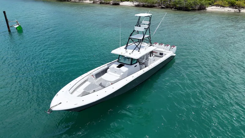 Slide: The Image of 2019 HCB 53 Sueños boat on clear turquoise water near a lush shoreline. - 12