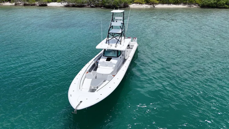 Slide: The Image of 2019 HCB 53 Sueños boat on clear turquoise water near a lush shoreline. - 13
