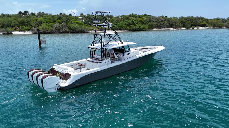 Slide: The Image of 2019 HCB 53 Sueños boat on clear blue water near a lush shoreline. - 4