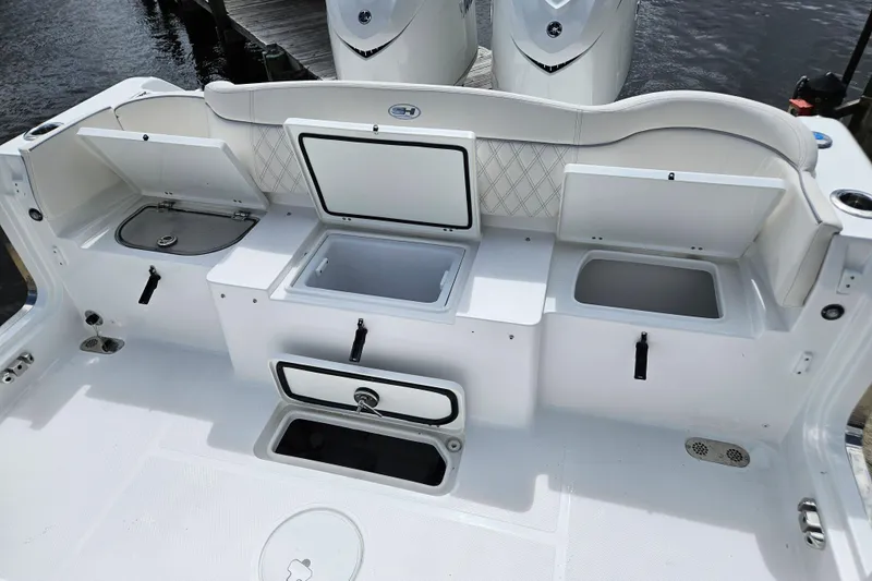 Slide: The Image of 2026 Sea Hunt Ultra 305 SE boat deck with storage compartments and seating. - 12