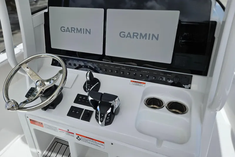 Slide: The Image of 2026 Sea Hunt Ultra 305 SE dashboard with Garmin displays and steering wheel. - 13