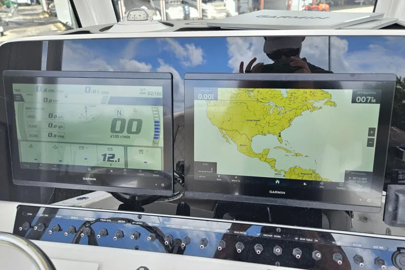 Slide: The Image of Dashboard of 2026 Sea Hunt Ultra 305 SE with Garmin navigation displays. - 14