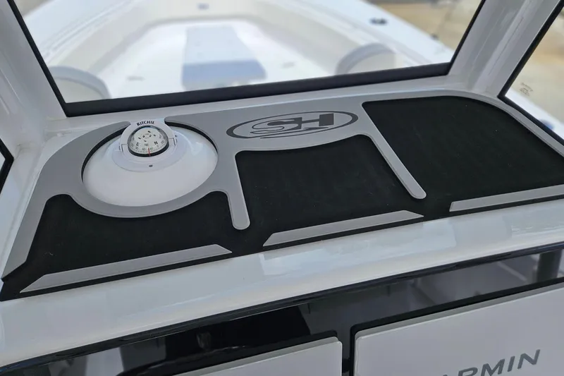 Slide: The Image of 2026 Sea Hunt Ultra 305 SE dashboard with compass and logo detail. - 18