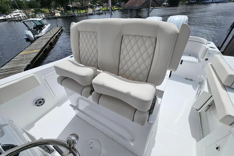 Slide: The Image of Luxurious seating on 2026 Sea Hunt Ultra 305 SE boat, docked by a serene waterfront. - 19
