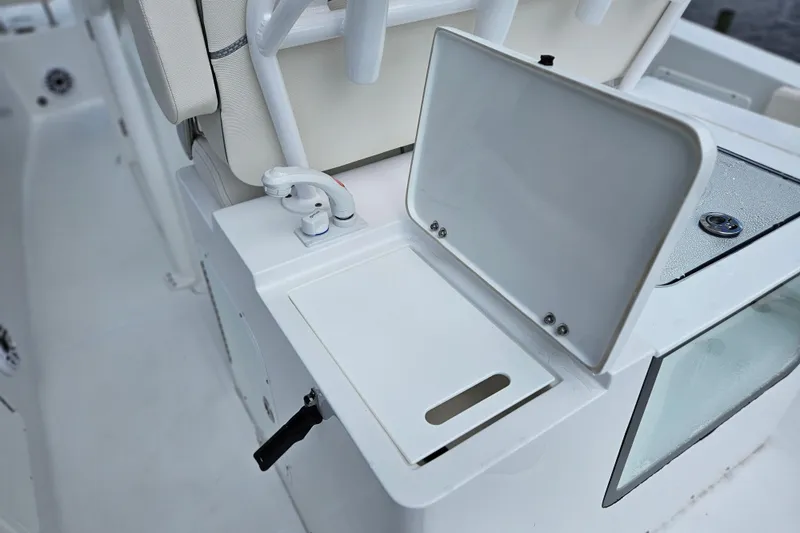 Slide: The Image of 2026 Sea Hunt Ultra 305 SE boat interior with open storage compartment and faucet. - 23