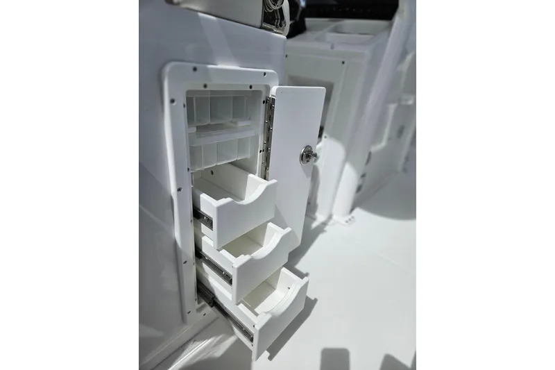Slide: The Image of Open storage compartment with drawers on a 2026 Sea Hunt Ultra 305 SE boat. - 26