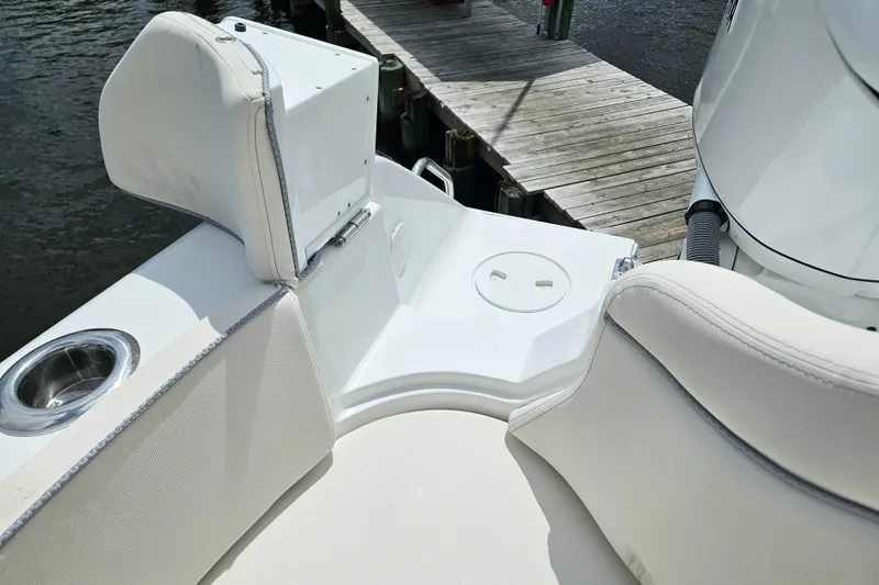 Slide: The Image of 2026 Sea Hunt Ultra 305 SE boat interior with cushioned seating and cup holder. - 35