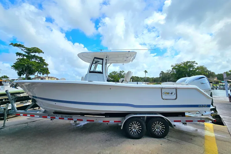 Slide: The Image of 2026 Sea Hunt Ultra 305 SE boat on trailer, dockside under blue sky. - 5