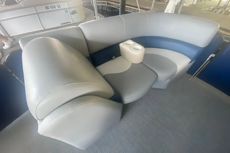 Slide: The Image of 2019 Manitou Aurora LE 23 RF VP boat interior with gray and blue seating and cup holders. - 10