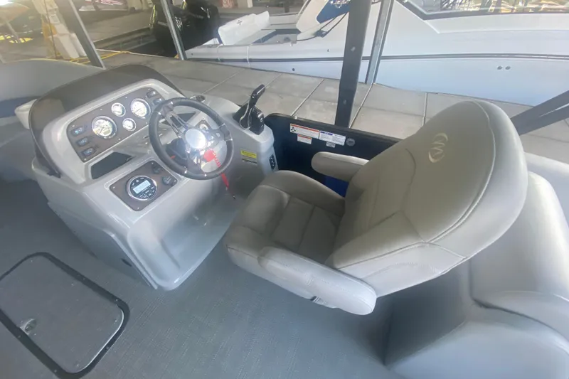 Slide: The Image of 2019 Manitou Aurora LE 23 RF VP boat interior with steering console and captain's chair. - 12