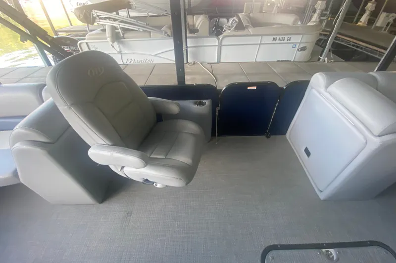 Slide: The Image of 2019 Manitou Aurora LE 23 RF VP boat interior with gray seating and helm chair. - 20