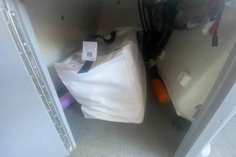 Slide: The Image of Storage compartment of 2019 Manitou Aurora LE 23 RF VP with white bag and equipment. - 29