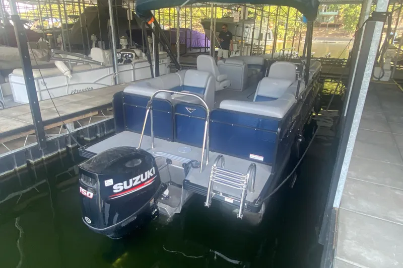 Slide: The Image of 2019 Manitou Aurora LE 23 RF VP pontoon boat with Suzuki 150 outboard motor in a marina. - 31
